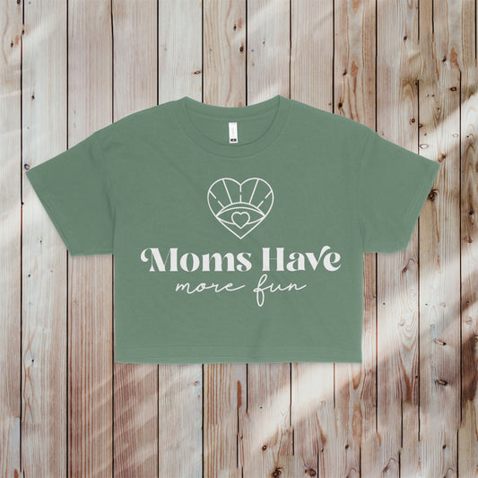 An image of the Moms Have More Fun Crop Tee in smoky sage, featuring a white signature heart and evil eye design, perfect for celebrating motherhood in style