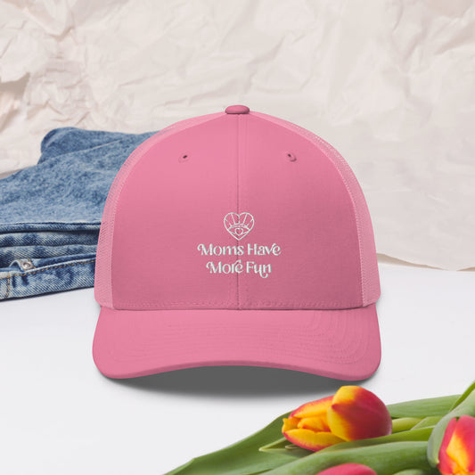 A stylish pink trucker hat for moms, featuring a classic design with a breathable mesh back and the Moms Have More Fun logo embroidered in white on the front.